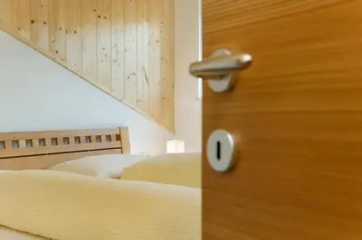 a wooden door in a bedroom with two beds at Wargerhof - Urlaub auf dem Bauernhof in Meltina