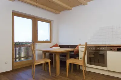 a kitchen with a table and a table and chairs at Wargerhof - Urlaub auf dem Bauernhof in Meltina