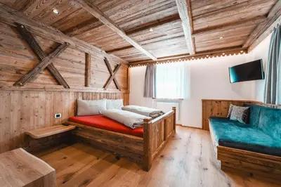 a bedroom with a bed and a couch at ALMRESIDENZ UNTERRAIN - with FREE SKI BUS SHUTTLE in Valdaora