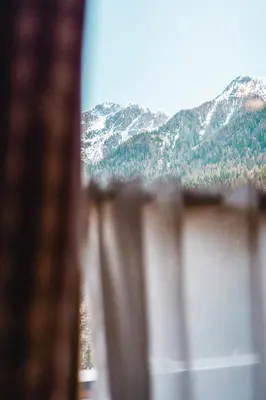 a large wooden bed in a room at ALMRESIDENZ UNTERRAIN - with FREE SKI BUS SHUTTLE in Valdaora
