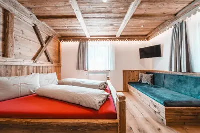 two beds in a room with wooden walls at ALMRESIDENZ UNTERRAIN - with FREE SKI BUS SHUTTLE in Valdaora