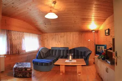 a living room with a blue couch and a table at Residence Landhaus Rainer in Ridanna
