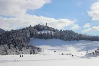 a snow covered slope with a church on a mountain at Residence Landhaus Rainer in Ridanna