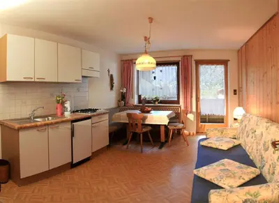 a kitchen and living room with a table and a couch at Residence Landhaus Rainer in Ridanna