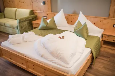 a room with two beds with towels on them at Hotel Salten in Avelengo