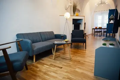 a living room with a blue couch and a table at Franz Haus Apartments in Merano