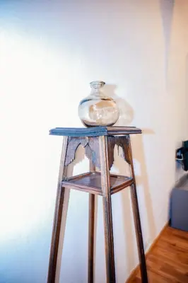a glass jar sitting on top of a wooden stool at Franz Haus Apartments in Merano
