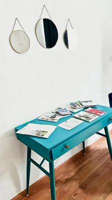 a blue table with two mirrors on a wall at Franz Haus Apartments in Merano