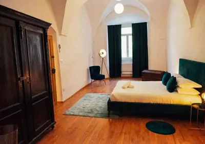 a bedroom with a bed and a chair and a window at Franz Haus Apartments in Merano