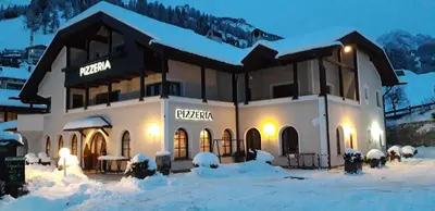 a building covered in snow in front at Villa Sella in Selva di Val Gardena