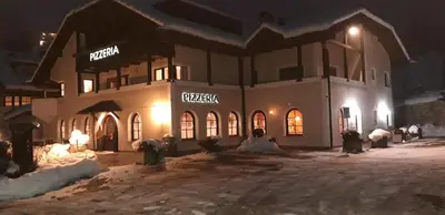 a building in the snow at night at Villa Sella in Selva di Val Gardena