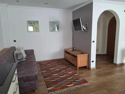 a living room with a couch and a tv at Villa Sella in Selva di Val Gardena