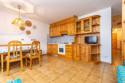 a kitchen with wooden cabinets and a table and chairs at Casa Maura in Soraga