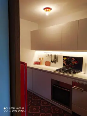 a kitchen with white cabinets and a stove top oven at TORRE GARDEN HOME - casa singola nella città di Bolzano con giardino privato in Bolzano