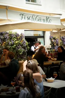 a group of people sitting at tables in a restaurant at Hotel Magdalener Hof in Bolzano