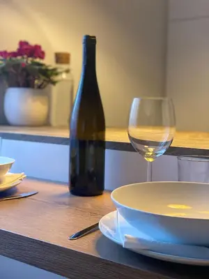 a table with a plate and a glass of wine at Ansitz von Wohlgemuth in Salorno sulla Strada del Vino