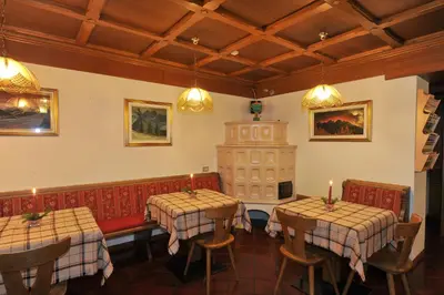 a dining room with two tables and a fireplace at Hotel Cristallo in Vigo di Fassa