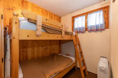 two bunk beds in a room with a ladder at Residence Marmolada in Pozza di Fassa