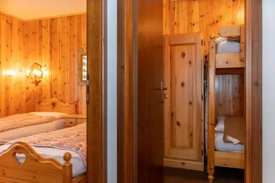 a bedroom with two beds and a bunk bed at Residence Marmolada in Pozza di Fassa