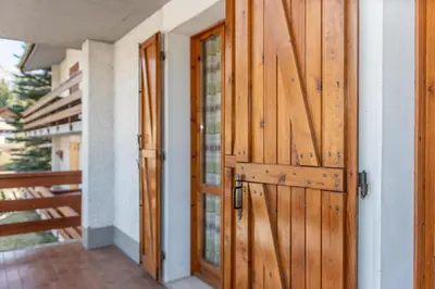 a pair of wooden doors on a house at Residence Marmolada in Pozza di Fassa