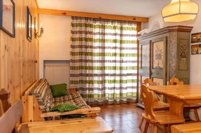 a living room with a table and a chair at Residence Marmolada in Pozza di Fassa