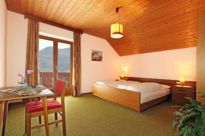 a bedroom with a bed and a desk and a table at Pirchnerhof in Longomoso