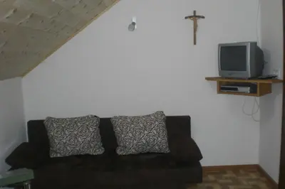 a living room with a black couch and a tv at Pirchnerhof in Longomoso
