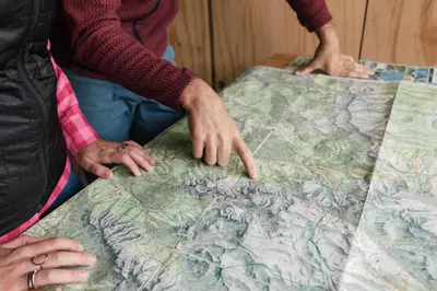 two people looking at a map on a table at Dolomitihouse CASTAGNER in Fiera di Primiero