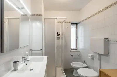 a white bathroom with a sink and a toilet at Dolomitihouse CASTAGNER in Fiera di Primiero