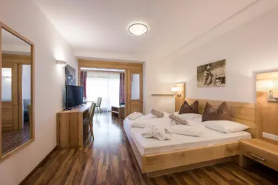 a hotel room with a bed and a television at Naturhotel Gruberhof in Schenna