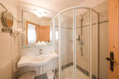 a bathroom with a sink and a shower at Naturhotel Gruberhof in Schenna