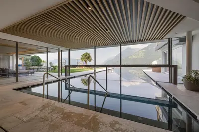 a swimming pool in the middle of a house at Naturhotel Gruberhof in Schenna