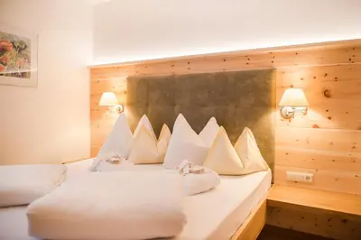 a bedroom with a large bed with white pillows at Naturhotel Gruberhof in Schenna