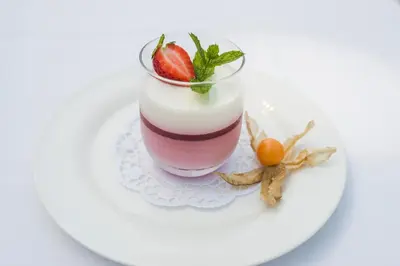 a dessert on a white plate with a strawberry at Naturhotel Gruberhof in Schenna
