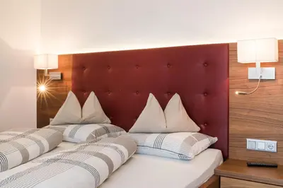 a bedroom with two beds with white pillows at Apartmenthaus Gruberhof in Schenna