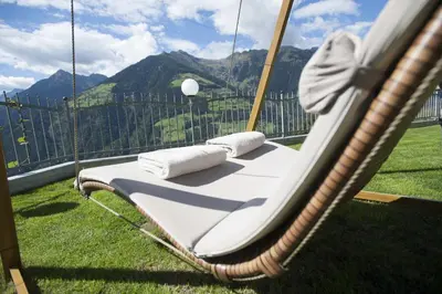 a porch swing with a view of a mountain at Apartmenthaus Gruberhof in Schenna