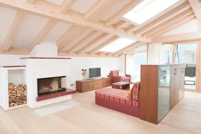 a living room with a fireplace and a couch at Apartmenthaus Gruberhof in Schenna