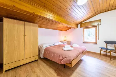 a bedroom with a bed and a wooden ceiling at Casa Mirabella in Sottoguda