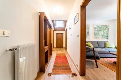 a hallway with a couch and a living room at Casa Mirabella in Sottoguda
