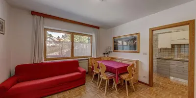 a living room with a red couch and a table at Cesa Elena in Canazei