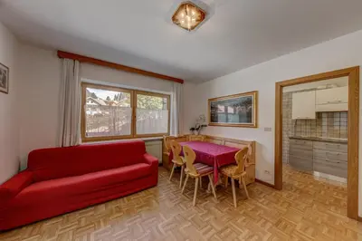 a living room with a red couch and a table at Cesa Elena in Canazei