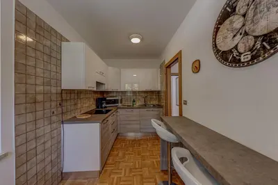 a kitchen with white cabinets and a counter top at Cesa Elena in Canazei