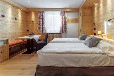 a bedroom with a large bed and a desk at Hotel Columbia & Spa in Cortina dʼAmpezzo