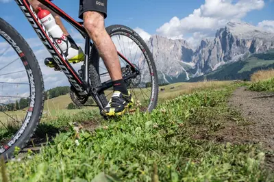 a man riding a bike on a mountain trail at Hotel Platz in Ortisei