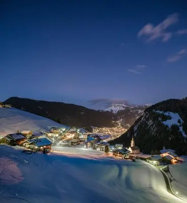a town in the mountains at night in the snow at Hotel Platz in Ortisei