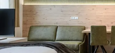 a bedroom with a couch and a desk with a computer at Villa Fauster Pustrabase in Villabassa