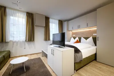 a hotel room with a bed and a flat screen tv at Villa Fauster Pustrabase in Villabassa