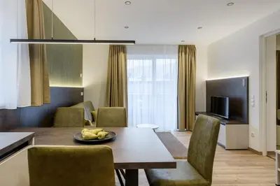 a kitchen and living room with a table and chairs at Sambock Quarter Pustrabase in Brunico