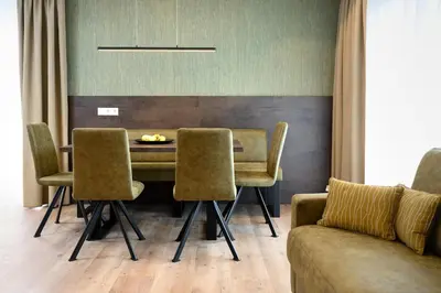 a dining room with a table and chairs and a couch at Sambock Quarter Pustrabase in Brunico