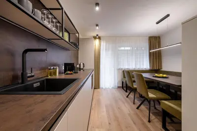 a kitchen with a sink and a table with chairs at Sambock Quarter Pustrabase in Brunico